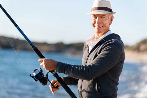 man smiling and holding a fishing rod