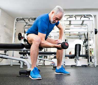 senior man lifting weights in the gym