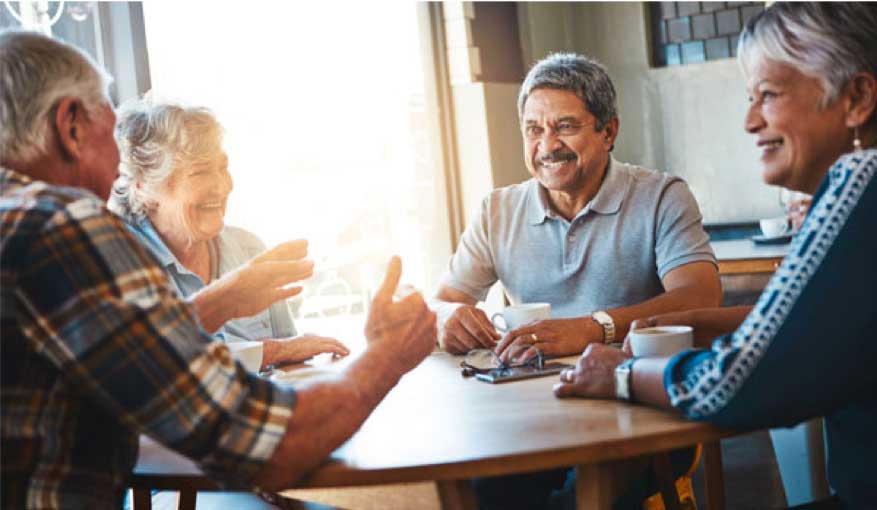 four adults talking at a table