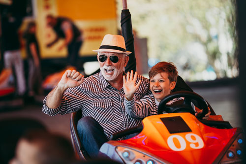 old man and child riding bumper cars
